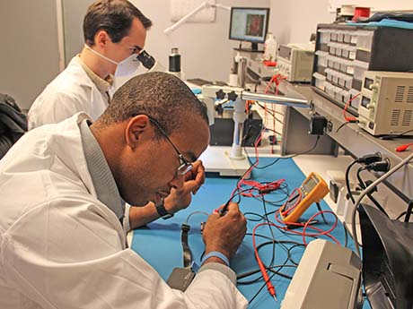 two people work on electronics