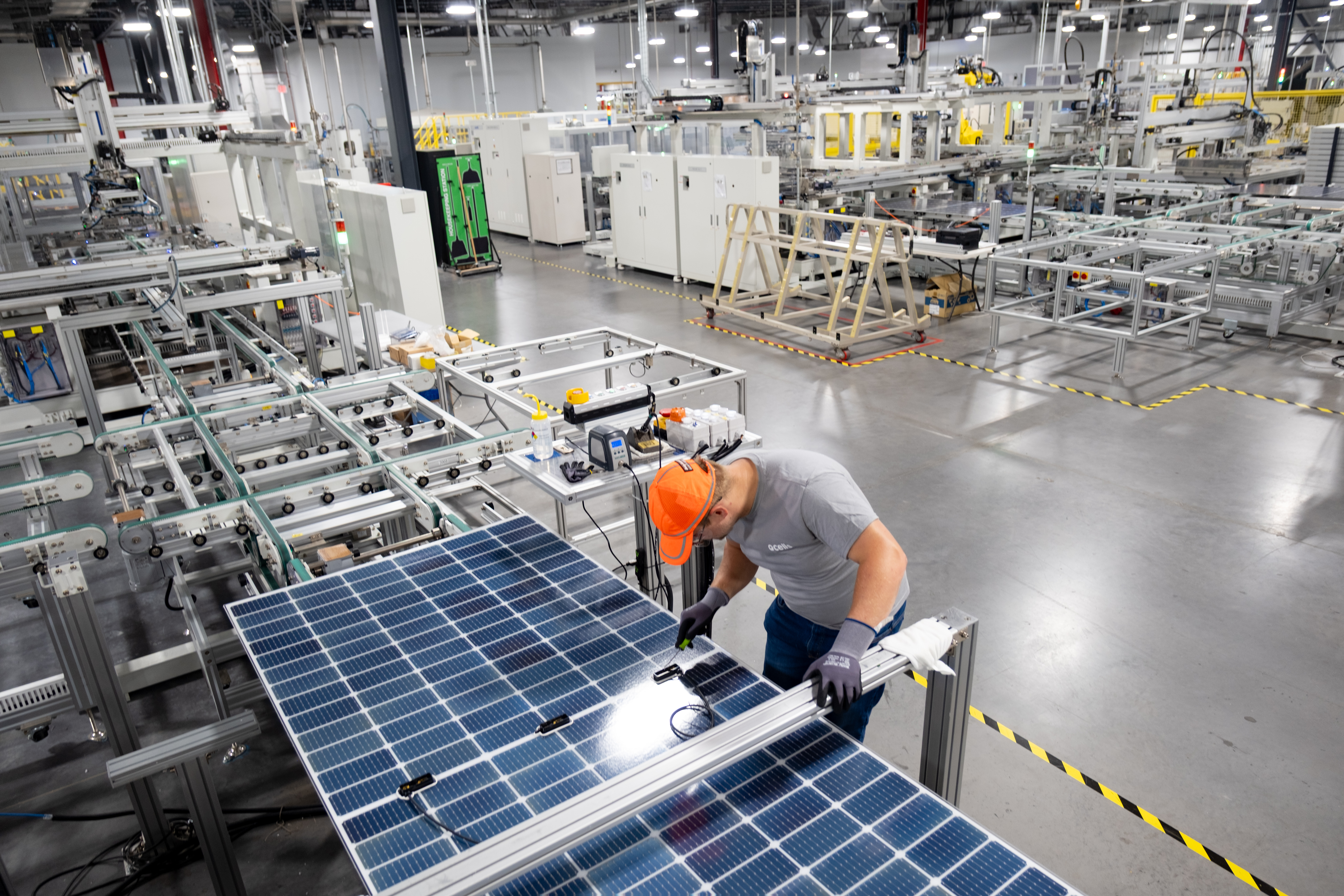 man with solar panel and orange hat.