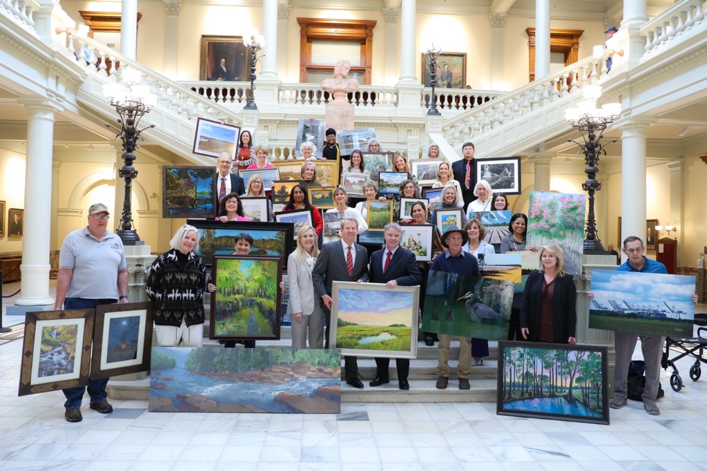 Artists holding their artwork. 