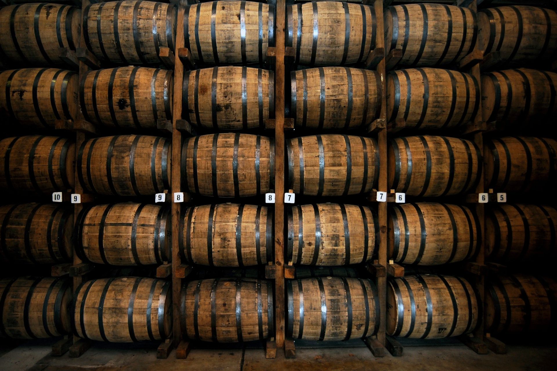  Rows of barrels are stacked and organized in a distillery.