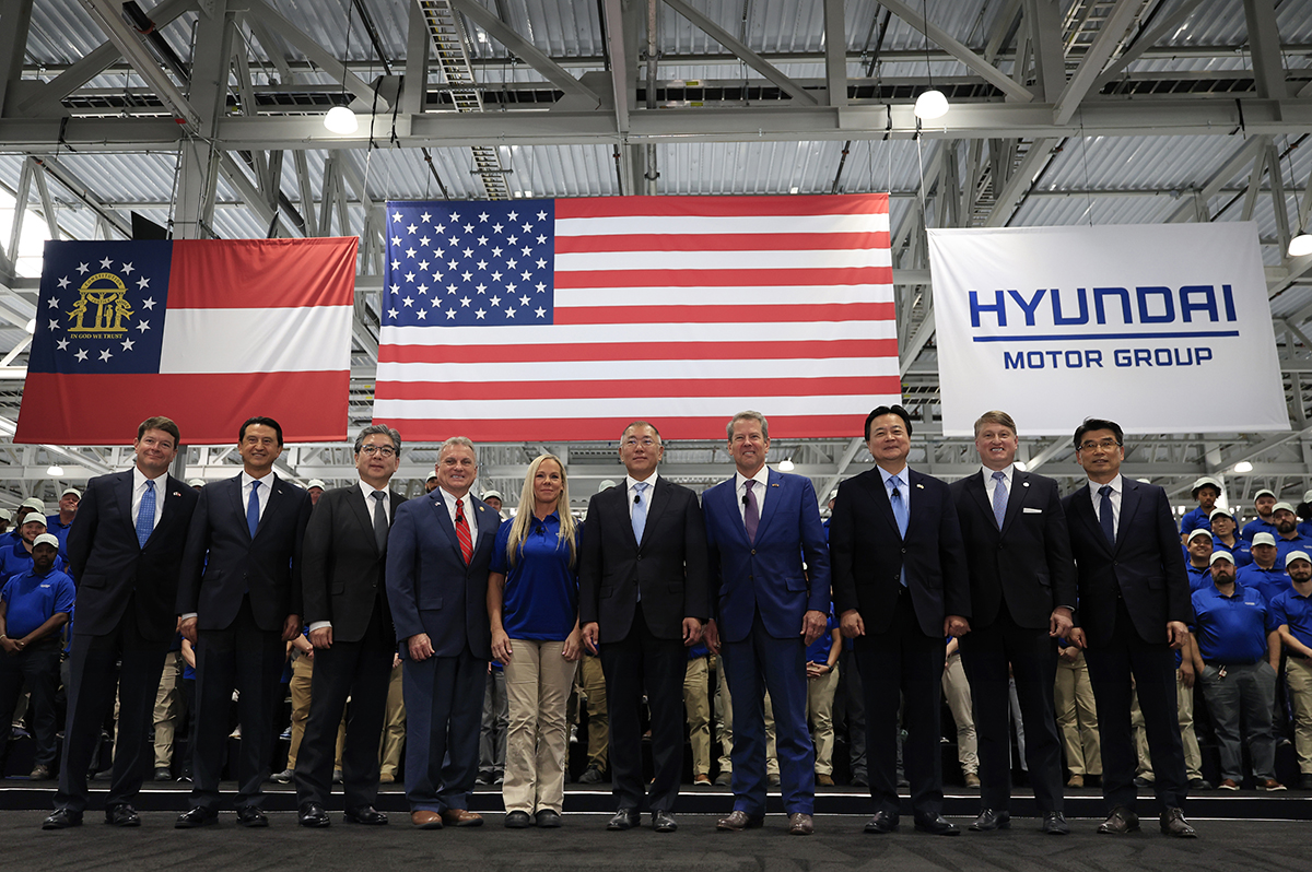 hyundai motor group and governor kemp standing in a line in front of usa ga and hyundai flag