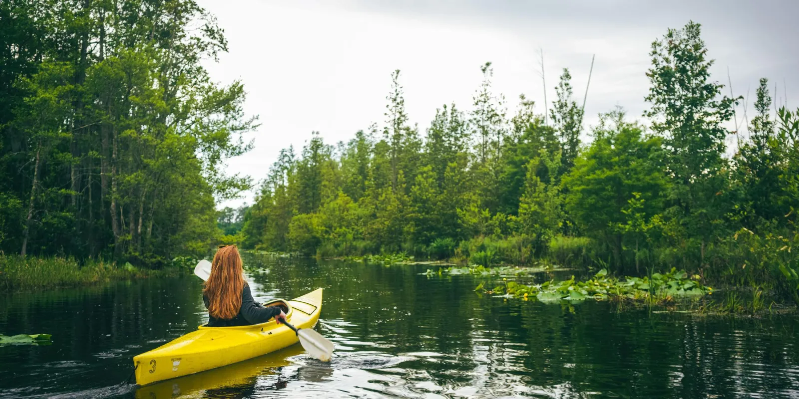 Woman paddling in a yellow kayak in the Okefenokee National Wildlife Refuge