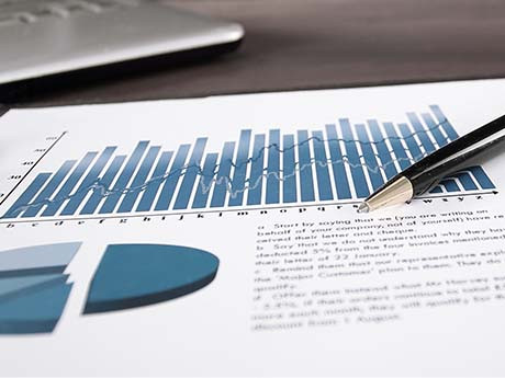 reports are highlighted on a piece of paper with a pen resting on it