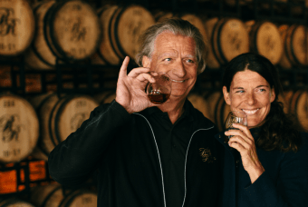 A man and woman holding two glasses in a distillery. Utilize the resources on this page to help scale and grow your existing business in Georgia.