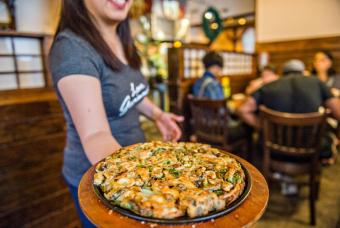 A server presents a tray of delicious Korean food at a restaurant on the Seoul of the South Tour