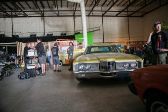 Crew on set inside a large building with a yellow classic vehicle in Georgia