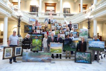 Artists holding their artwork. 