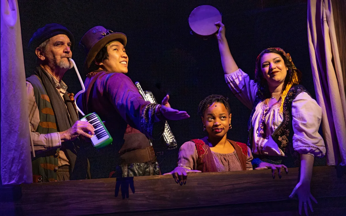 Four people performing in a musical
