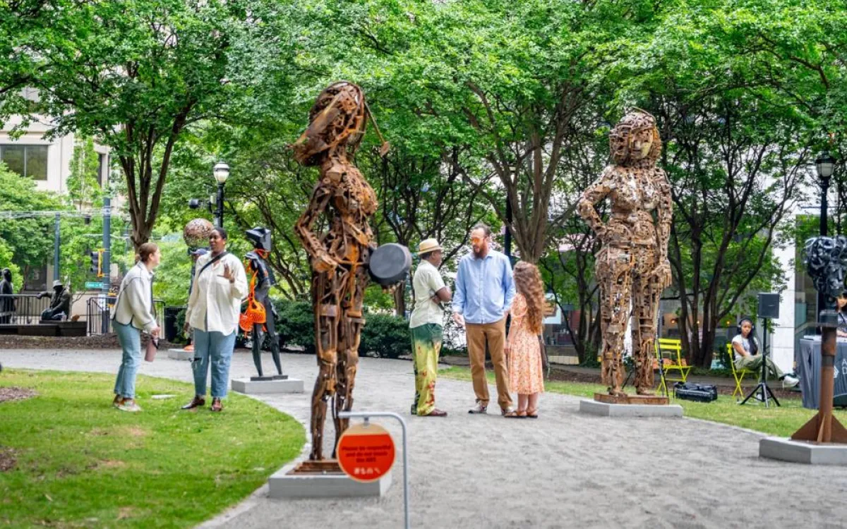 people standing among art sculptures in a park