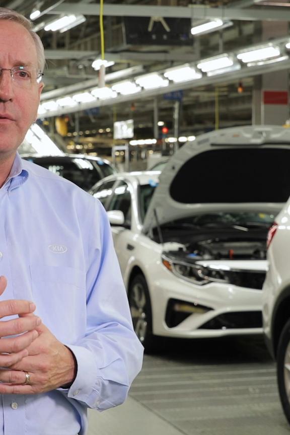 Leader at Kia stands in front of vehicles in West Central Georgia