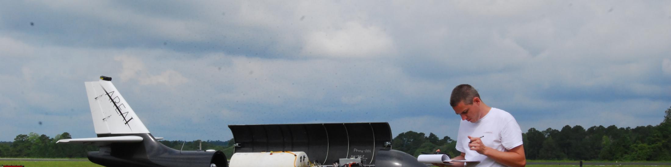 Man standing next to plane taking notes in Georgia