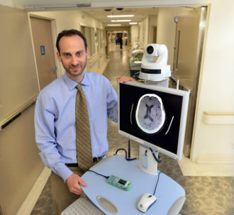 life sciences employee shows a screen with a brain scan