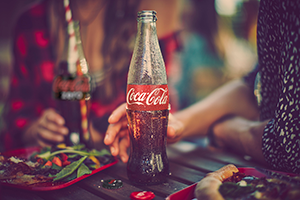 a close up of a hand holding a coca-cola bottle