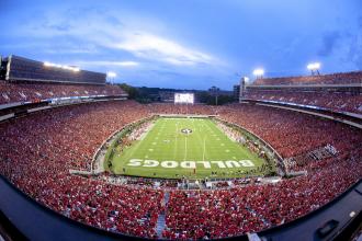 Football stadium filled with fans near sunset