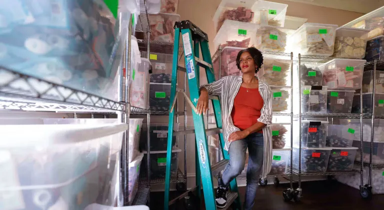 Owner of Ecoslay in a room with bins of products