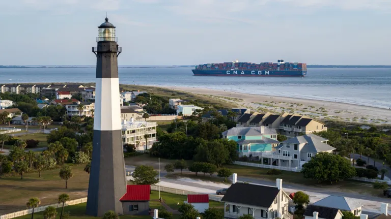 Georgia Lighthouse with a cargo ship in the background.