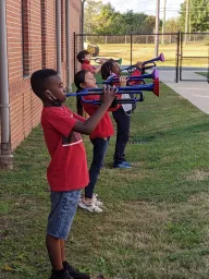 Children playing instruments outside