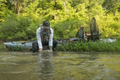 Fisherman with trout and a Crescent Kayak