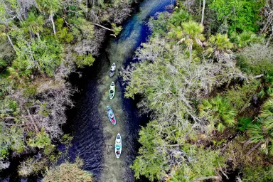 Aerial view of four Crescent Kayaks navigating a river