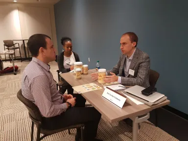 Tru-Nut representative speaking about the company's products at a table with two other people
