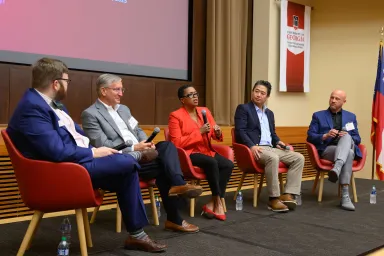 Five panelists on stage at the UGA Electric Mobility Summit