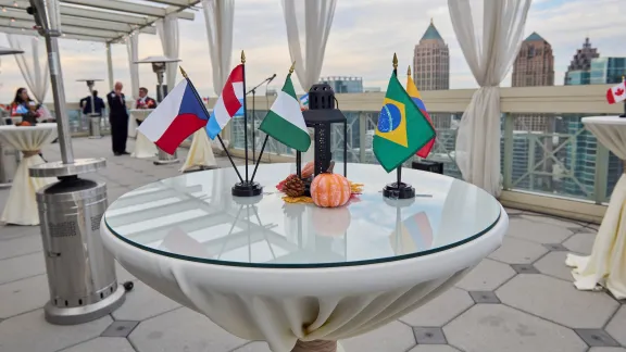 Flags from around the world displayed on a table on a rooftop patio overlooking the Atlanta skyline