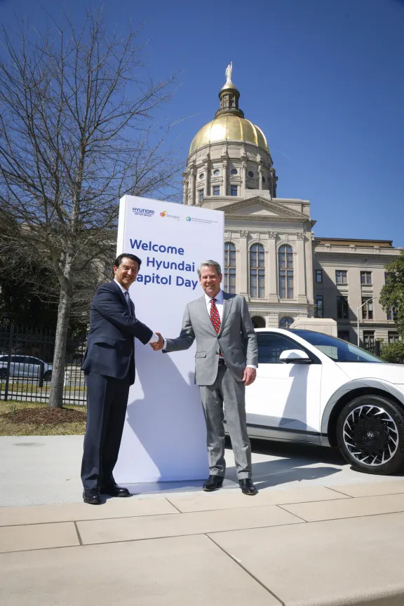 Governor Kemp and Hyundai rep shake hands in front of Capitol